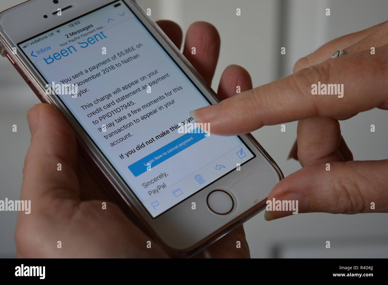Scam-E-Mail, die angeblich von Paypal, bitten Empfänger Jetzt einloggen, auf ein Handy mit Finger einer Frau, die auf dem Touchscreen angezeigt. Stockfoto