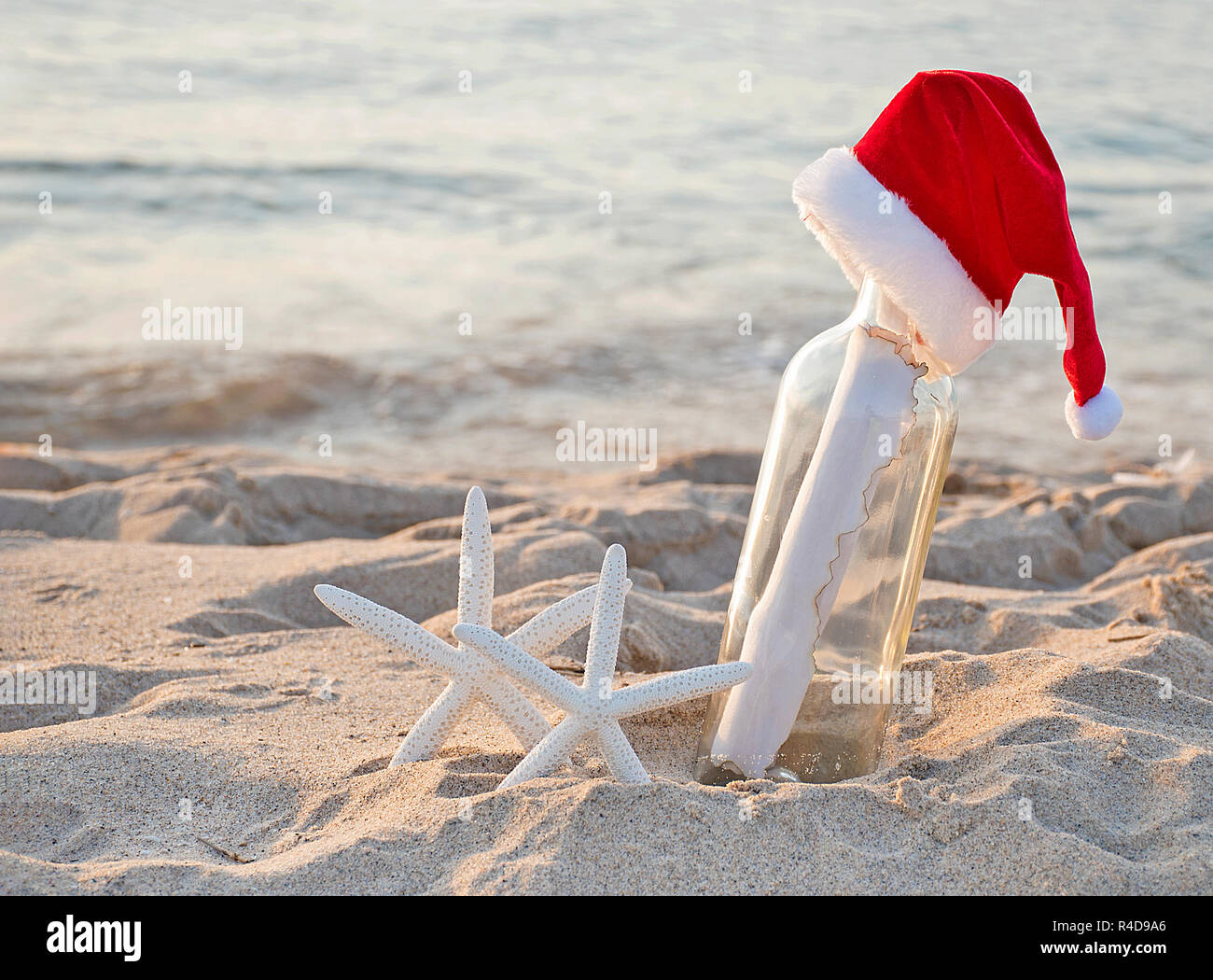 Santa Hut auf Nachricht in einer Flasche mit weißer Seestern in Strand sand Stockfoto