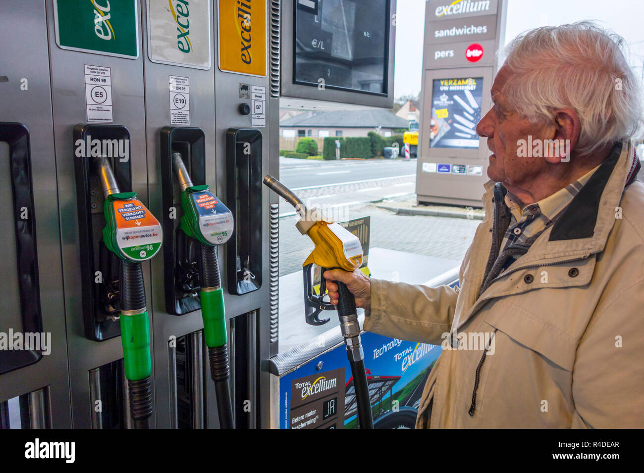 Älterer mann Auswahl Diesel Pumpe Düse und teuren Preis an der Zapfsäule der Tankstelle tanken sein Auto in Belgien, Europa Stockfoto