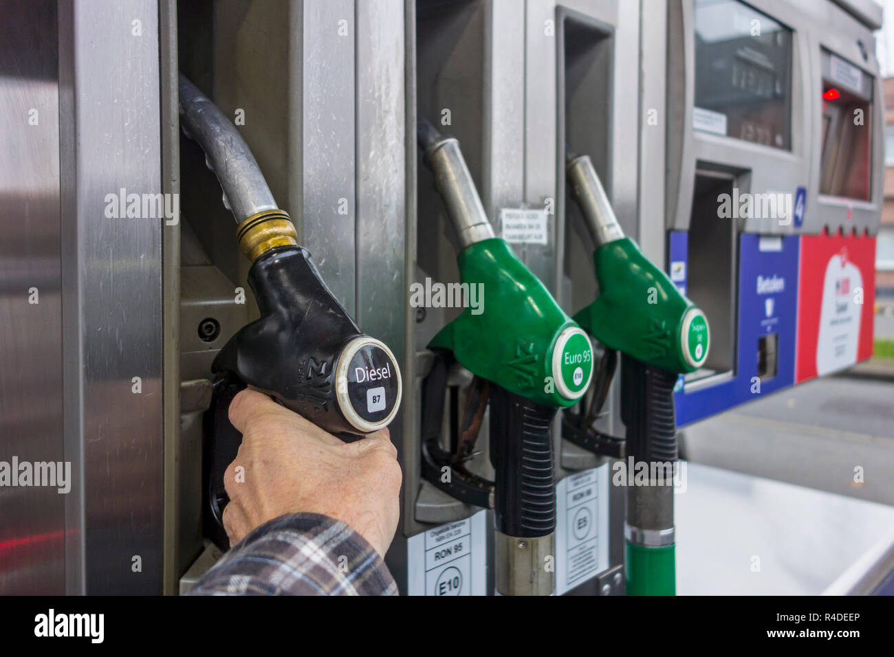 Mann Auswahl Diesel Pumpe Düse an der Tankstelle tanken sein Auto in Europa Stockfoto