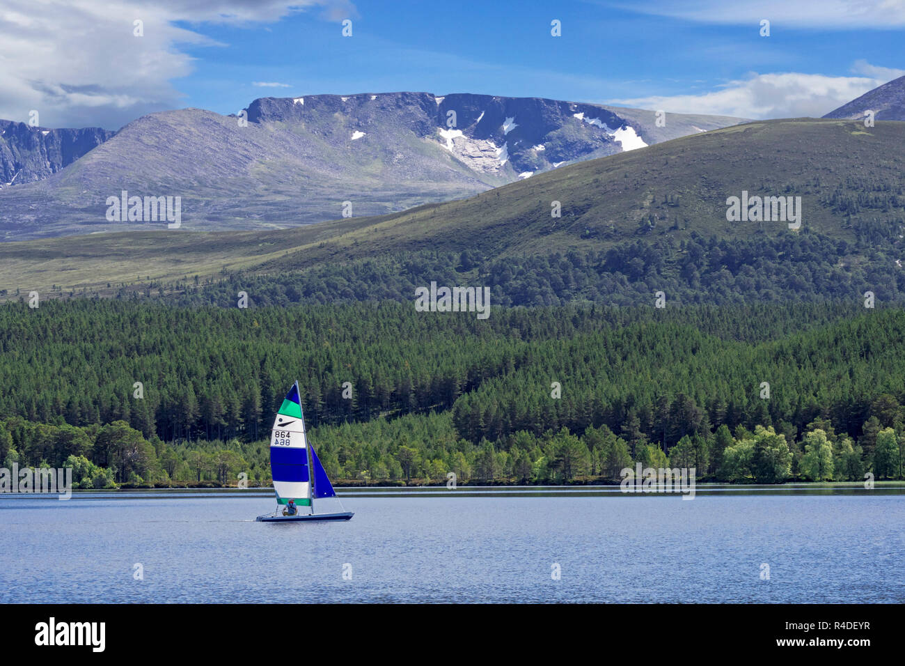 Segelboot auf dem Loch Morlich vor der Cairngorm Mountains, Cairngorms National Park, Badenoch und Strathspey, Highland, Schottland, UK Stockfoto