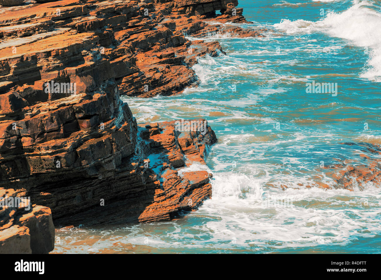 Blue Ocean Wellen gegen die Felsen und Ufer. Stockfoto