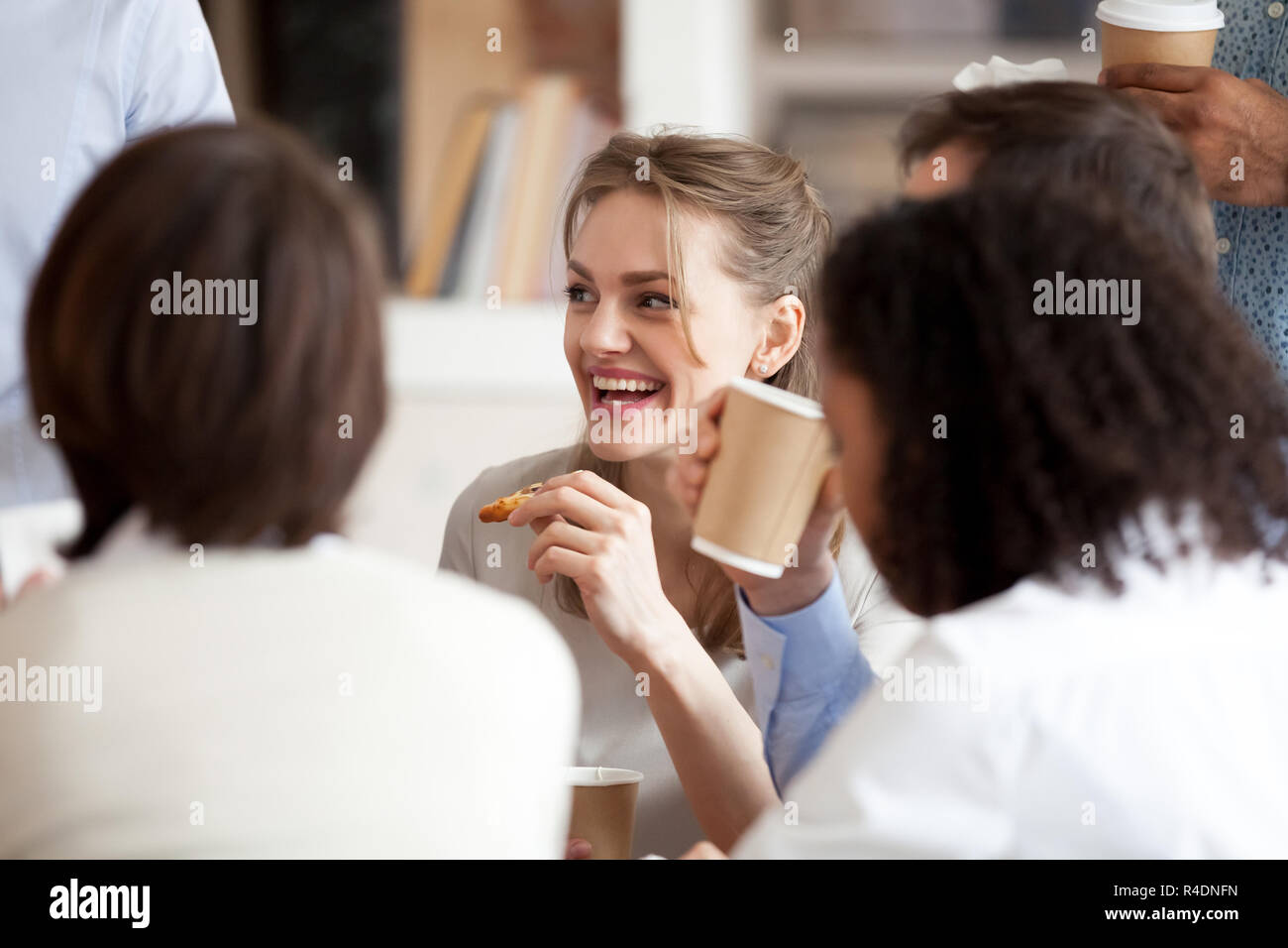 Lächelnd Geschäftsfrau essen Pizza mit Kollegen in die Pause Stockfoto