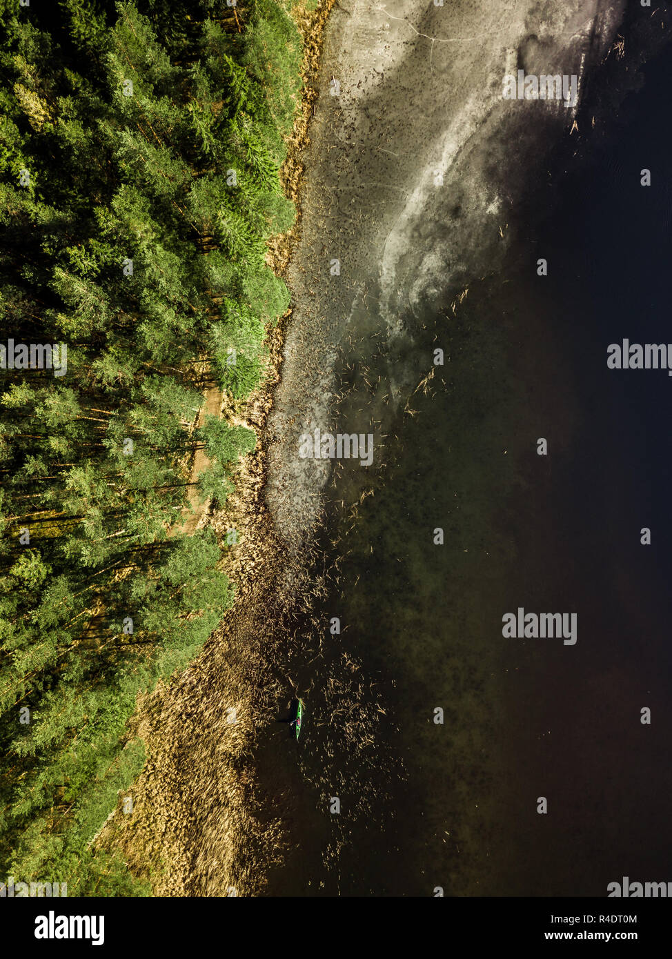 Antenne Drone Foto eines teilweise zugefrorenen See in einer verschneiten Frühjahr mit einem Boot Silhouette in Abstand Stockfoto