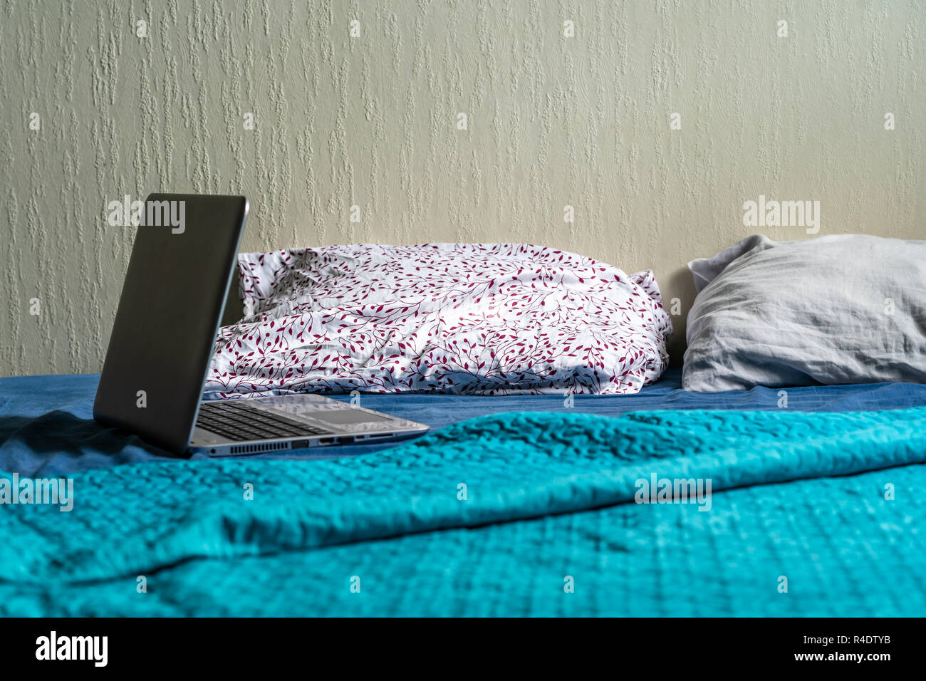 Grau Laptot Verlegung auf Matratze mit Türkis, ein paar Kissen und einem weißen Hintergrund - für Student's Studien Stockfoto