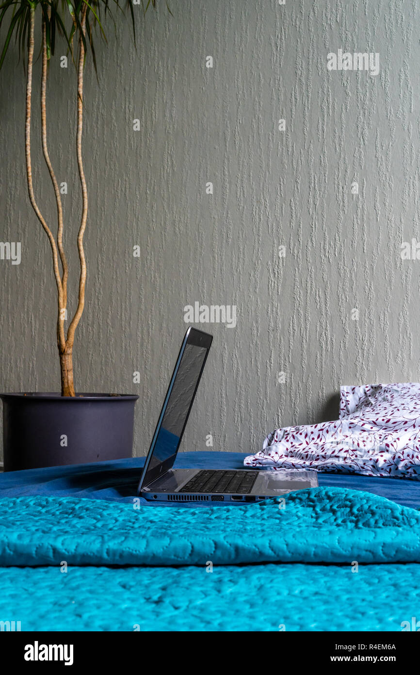 Grau Laptot Verlegung auf Matratze mit Türkis, ein paar Kissen und einem weißen Hintergrund - mit einem Zimmer Anlage neben Es Stockfoto