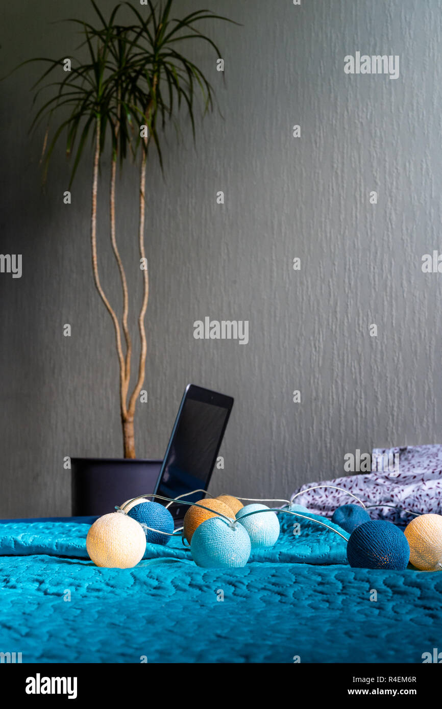 Grau Laptot Verlegung auf Matratze mit Türkis, ein paar Kissen und einem weißen Hintergrund - mit einem Zimmer Anlage außer Ihm und Weihnachten Dekoration Leuchten Stockfoto
