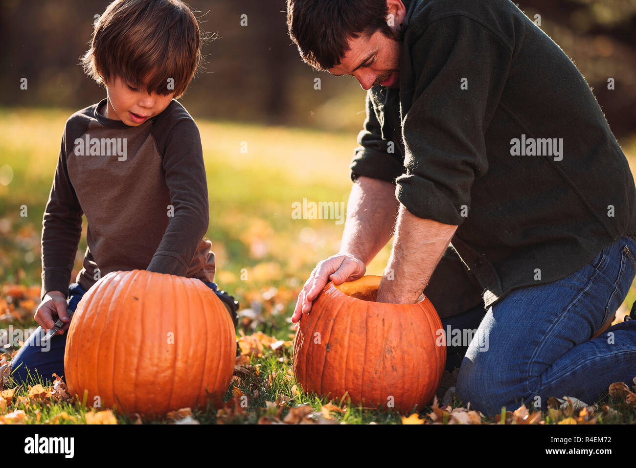 Vater und Sohn schnitzen Halloween Kürbisse, United States Stockfoto