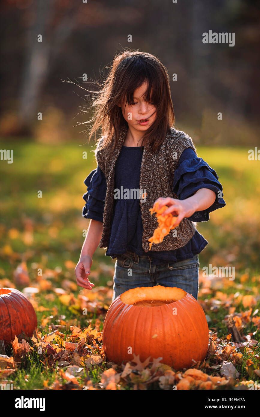 Mädchen das Schnitzen eines Halloween Kürbis im Garten, United States Stockfoto