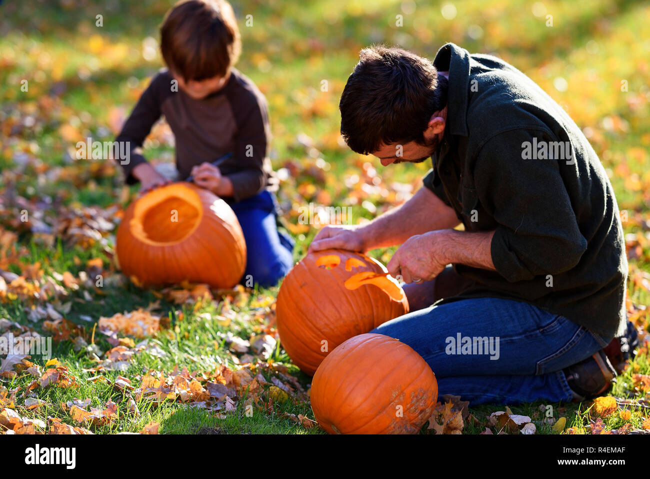 Vater und Sohn schnitzen Halloween Kürbisse, United States Stockfoto