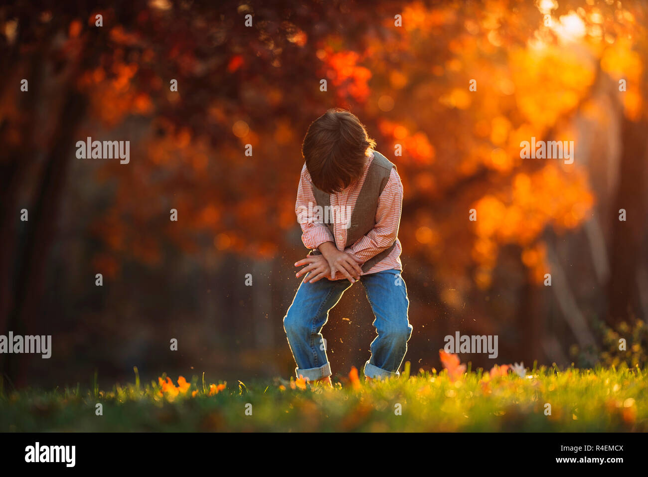 Junge draußen Bürsten Gras seine Hose aus, Vereinigtes Königreich Stockfoto