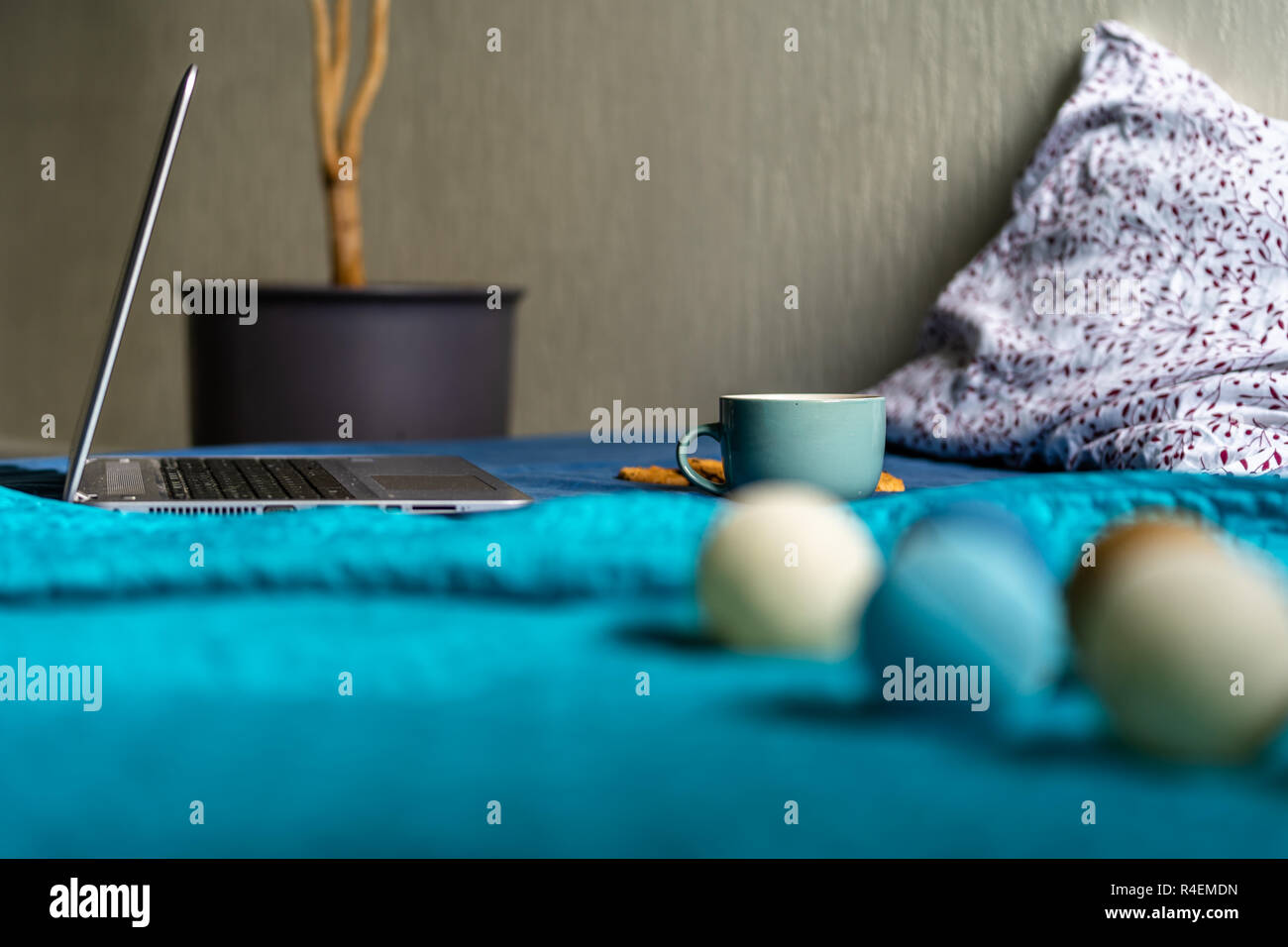 Tee mit Zitrone und Kekse mit Schokolade Verlegung auf Matratze - Weihnachten Dekoration Licht Kugeln und grau Laptop Neben es Stockfoto