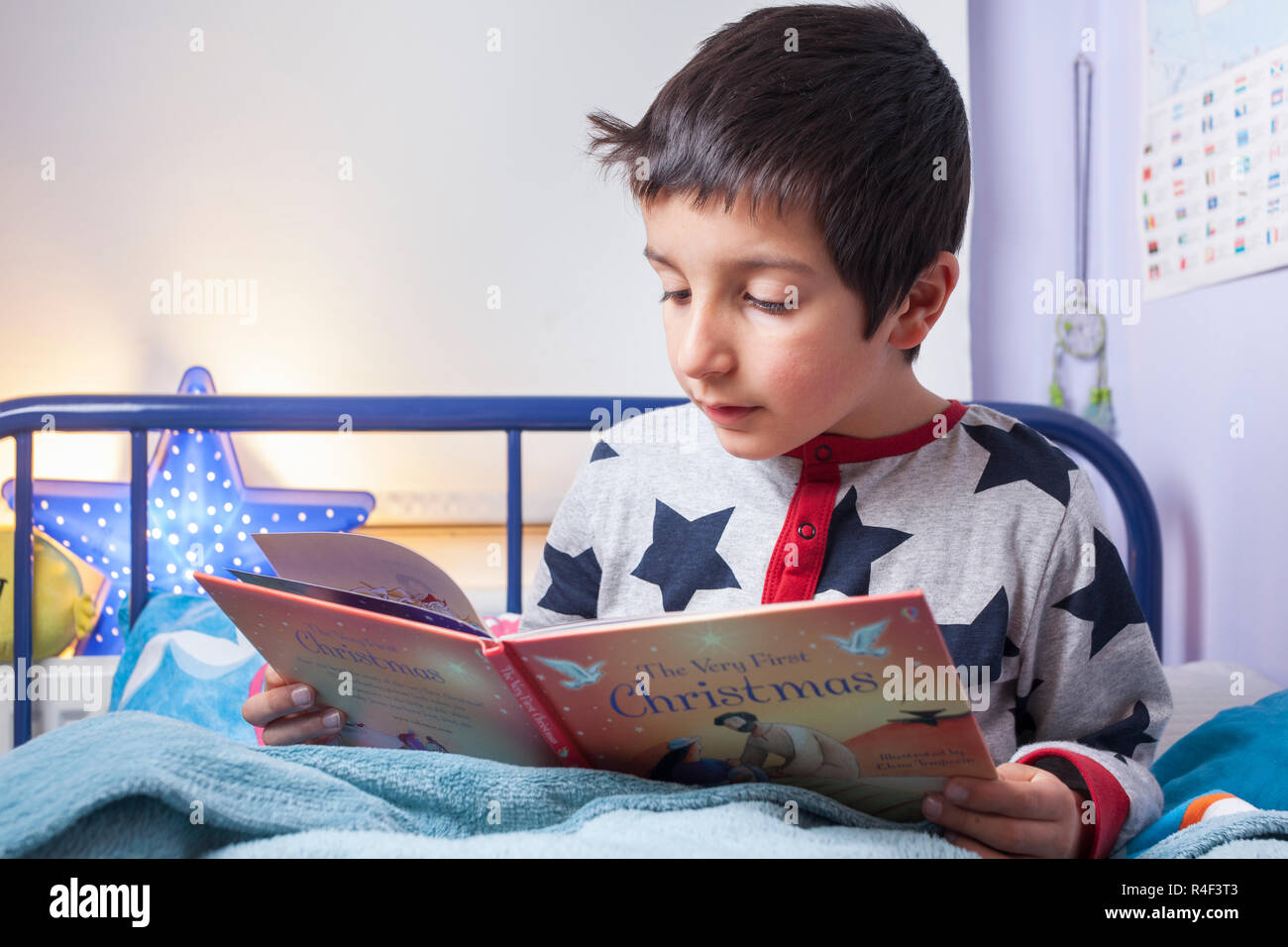 UK, Junge ,6 Jahre alt liest im Bett Stockfoto