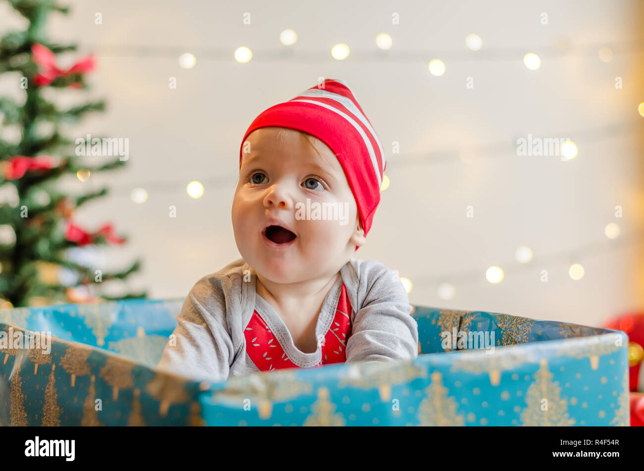Frohe Weihnachten Baby Mädchen in ein Kästchen um Weihnachtsbaum und Dekorationen Stockfoto