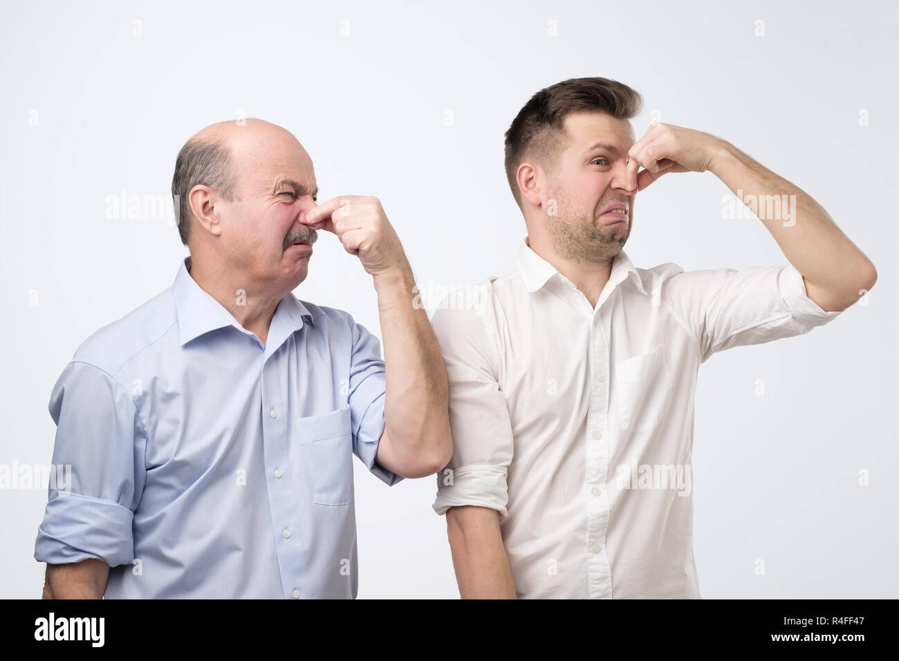 Zwei Männer umfassen ihre Nasen aufgrund einer schlechten Geruch Stockfoto