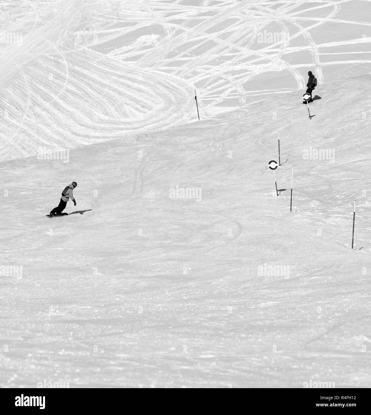 Zwei Snowboarder bergab auf verschneiten Freeride bei Sun kalten Tag verfolgen. Kaukasus Berge im Winter, Georgien, Region Gudauri. Schwarz und Weiß getönten Landsc Stockfoto