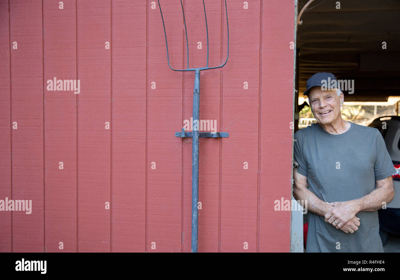 Senior Rancher steht die Scheune Stockfoto