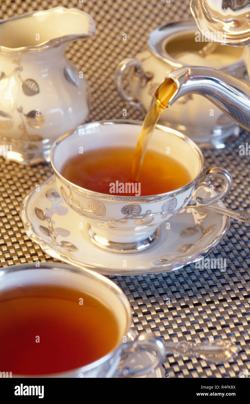 Strömenden heißen Tee für eine elegante Kaffee Service Stockfoto