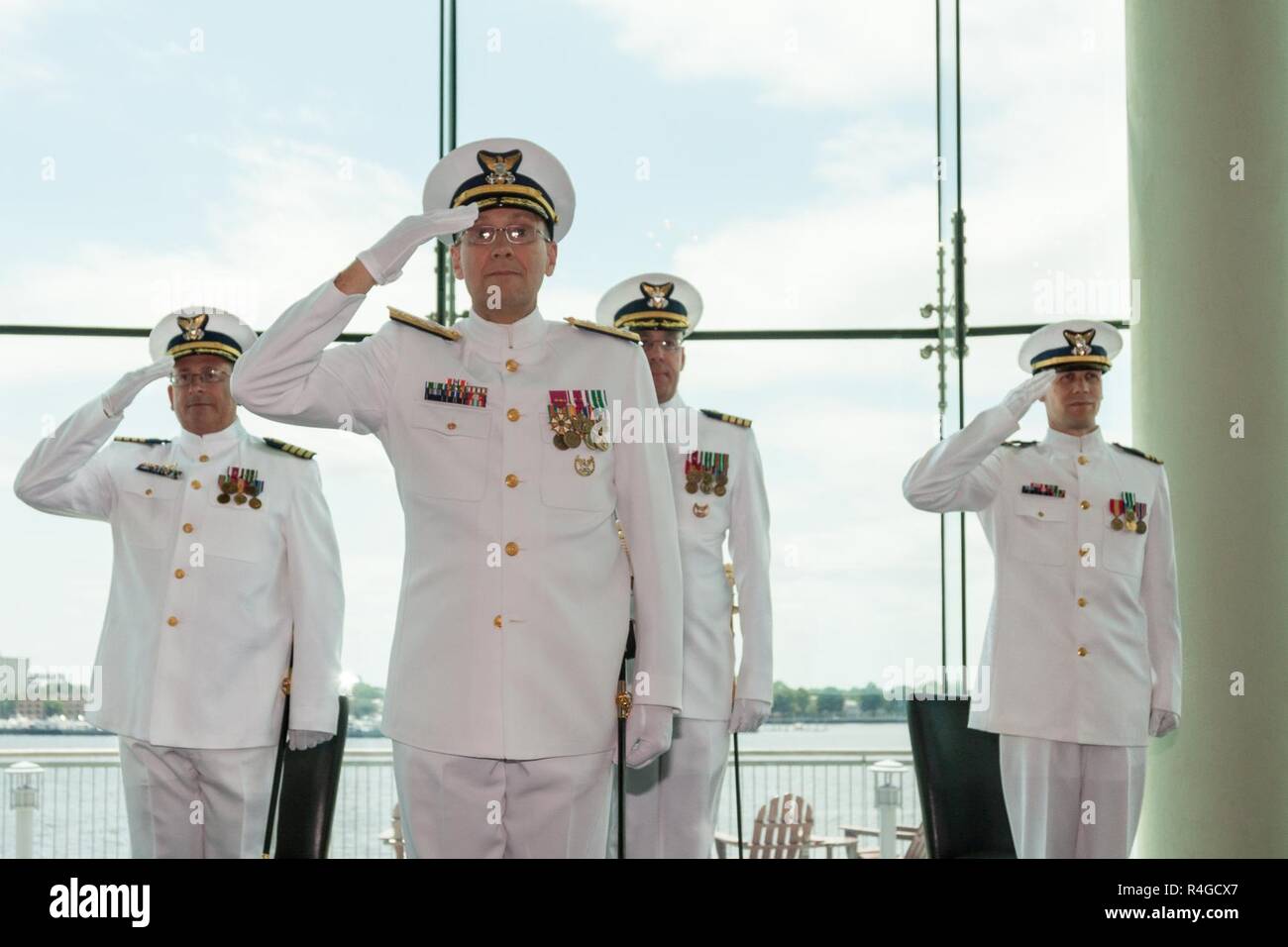 Norfolk, VA-Coast Guard hinten Adm. Thomas Jones, stellvertretender Kommandant für die Mission unterstützen, Kapitän George Bonner, ausgehende Kommandant der Ufer Infrastruktur Logistik Zentrum, Kapitän Wade Gesele, eingehende Kommandant der SILC, und Leutnant Cdr. Thomas Warren, Salute bei der Ankunft der offiziellen Partei an der SILC-Change-of-Befehl Zeremonie an der Half Moon Kreuzfahrt und Feier in Norfolk, Virginia, 4. Mai 2017. Die Change-of-Befehl Zeremonie ist eine altehrwürdige militärische Tradition gehalten, um einen nahtlosen Übergang zwischen den einzelnen Befehlen zu gewährleisten. Stockfoto