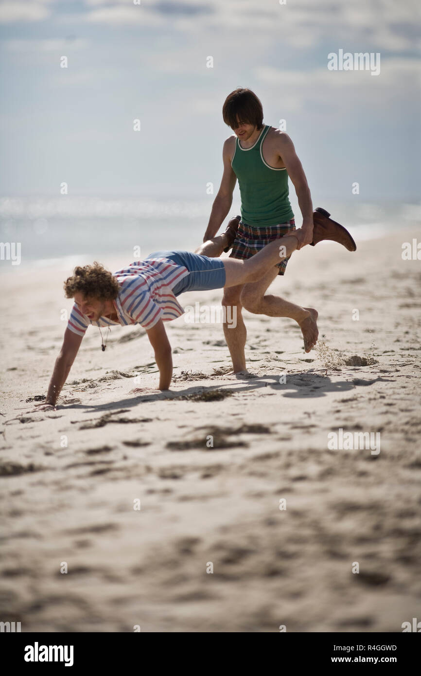 Junge Männer spielen am Strand Stockfoto