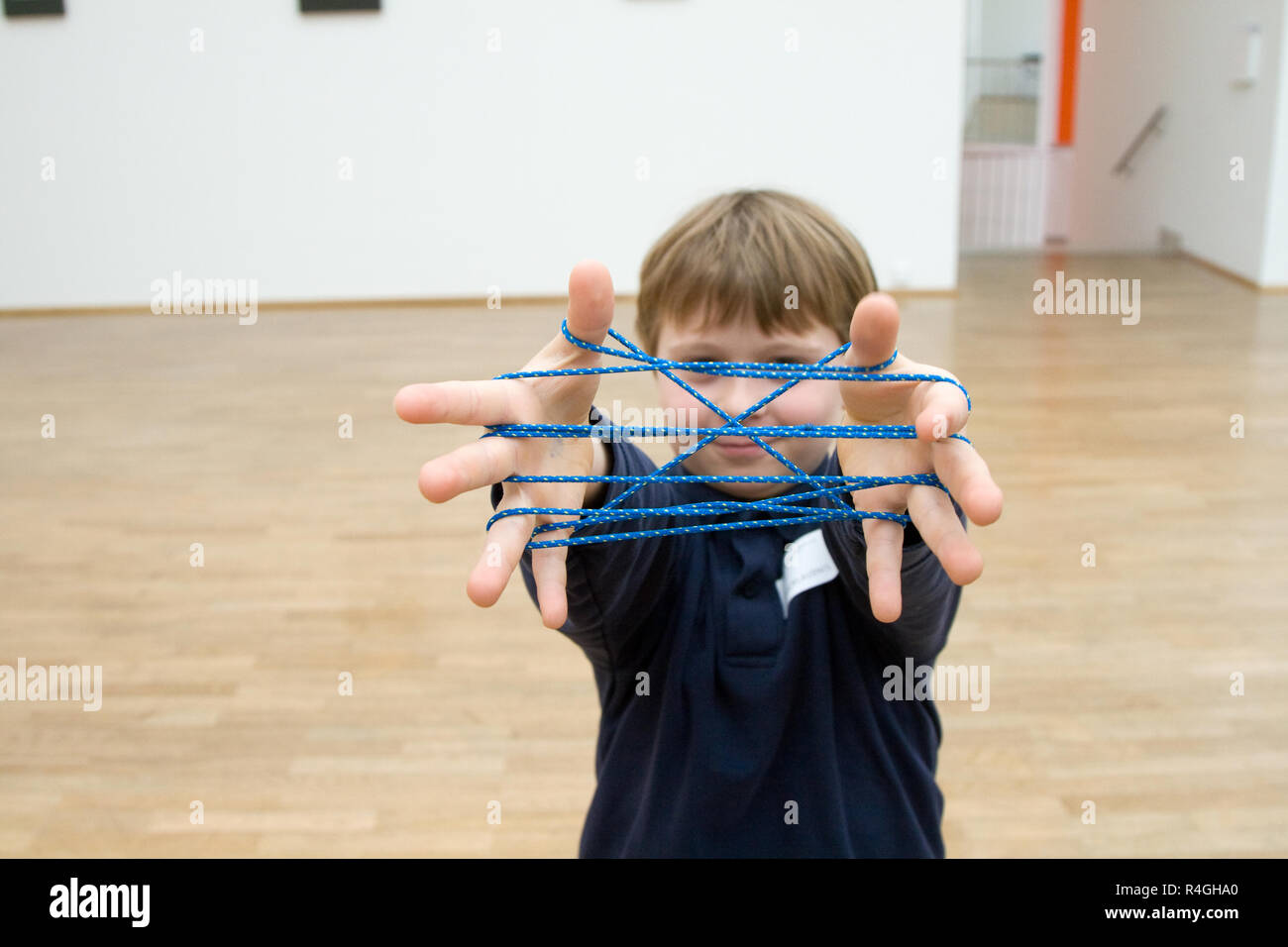Junge spielt eine handgame mit einer Band in ein Museum für moderne Kunst, er genießt es Stockfoto