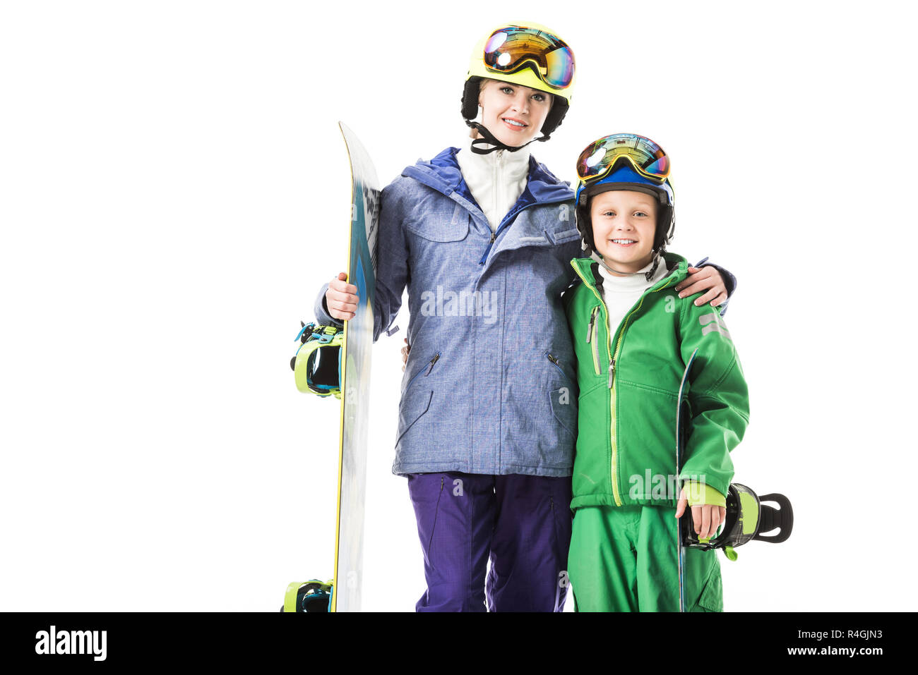 Lächelnd Mamma und jugendlichen Sohn in Ski Anzüge mit Snowboards umarmen und mit Blick auf die Kamera isoliert auf weißem Stockfoto