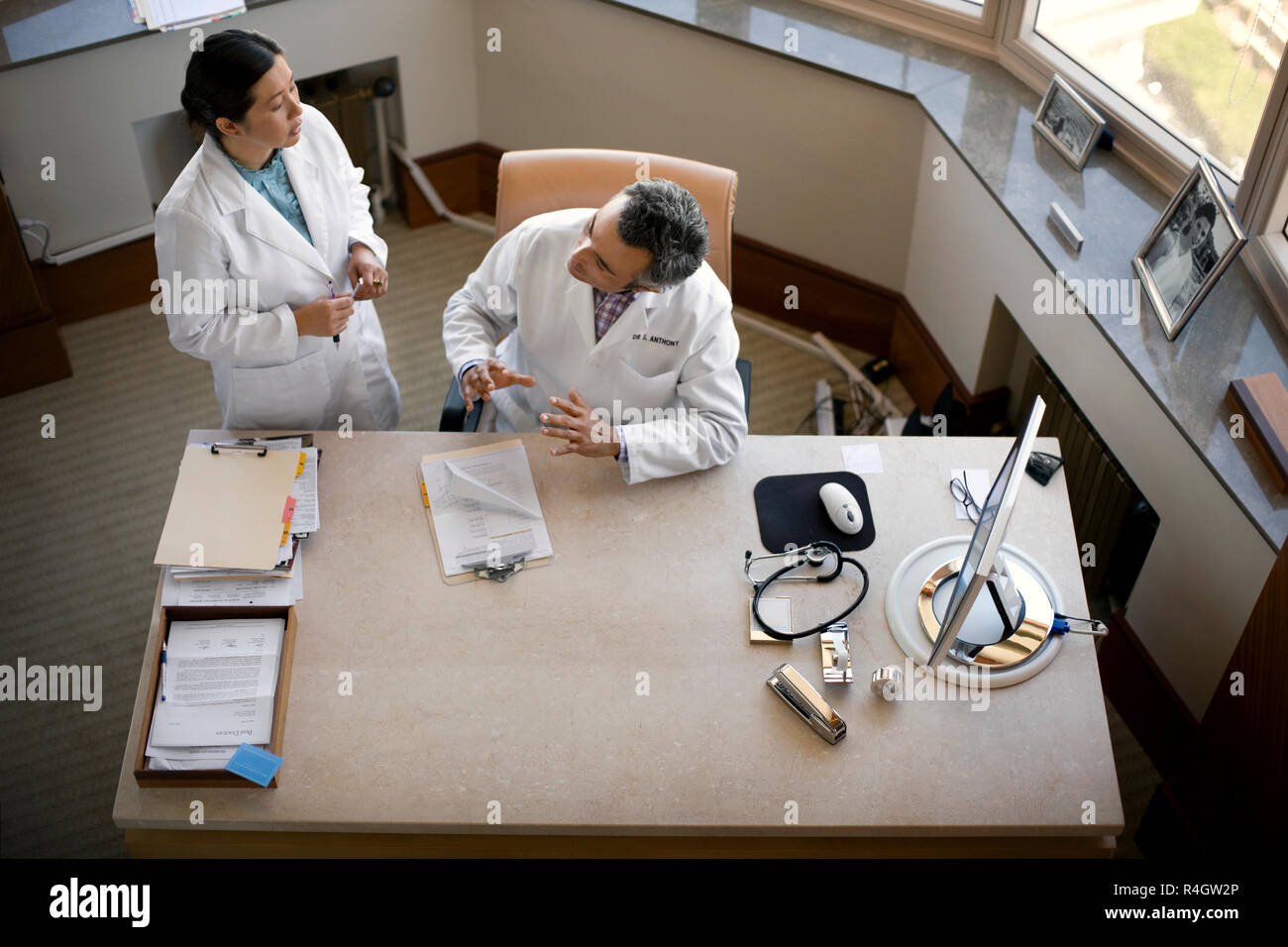 Mitte der erwachsenen Arzt Beratung mit einem älteren Supervisor in ihrer Praxis. Stockfoto