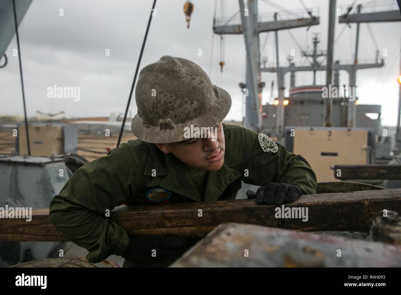 Us Marine Corps Lance Cpl. Johnathan Galeasse, eine mobile Instandhaltung Mechaniker Marine Aviation Logistics Squadron 26 zugewiesen, beobachtet ein stahlseil an einem Kran System angeschlossen an Bord der Luftfahrt Logistik Schiff SS Wright (T-AVB-3), in Vorbereitung auf die Trident Punkt 18 an der Morehead City, N.C., Sept. 28, 2018. Trident Stelle ist Teil einer geplanten Übung Serie zur Verbesserung der US- und NATO-Verbündeten Fähigkeiten zur Zusammenarbeit militärische Operationen unter schwierigen Bedingungen durchzuführen. Stockfoto