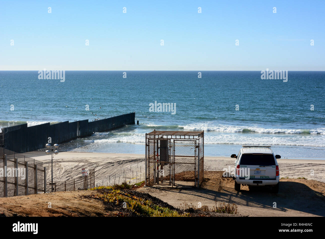 SAN YSIDRO, Kalifornien - November 26, 2018: ein Border Patrol Fahrzeug Uhren über den Strand und die Grenzmauer, der in den Ozean erstreckt, am Imperial. Stockfoto