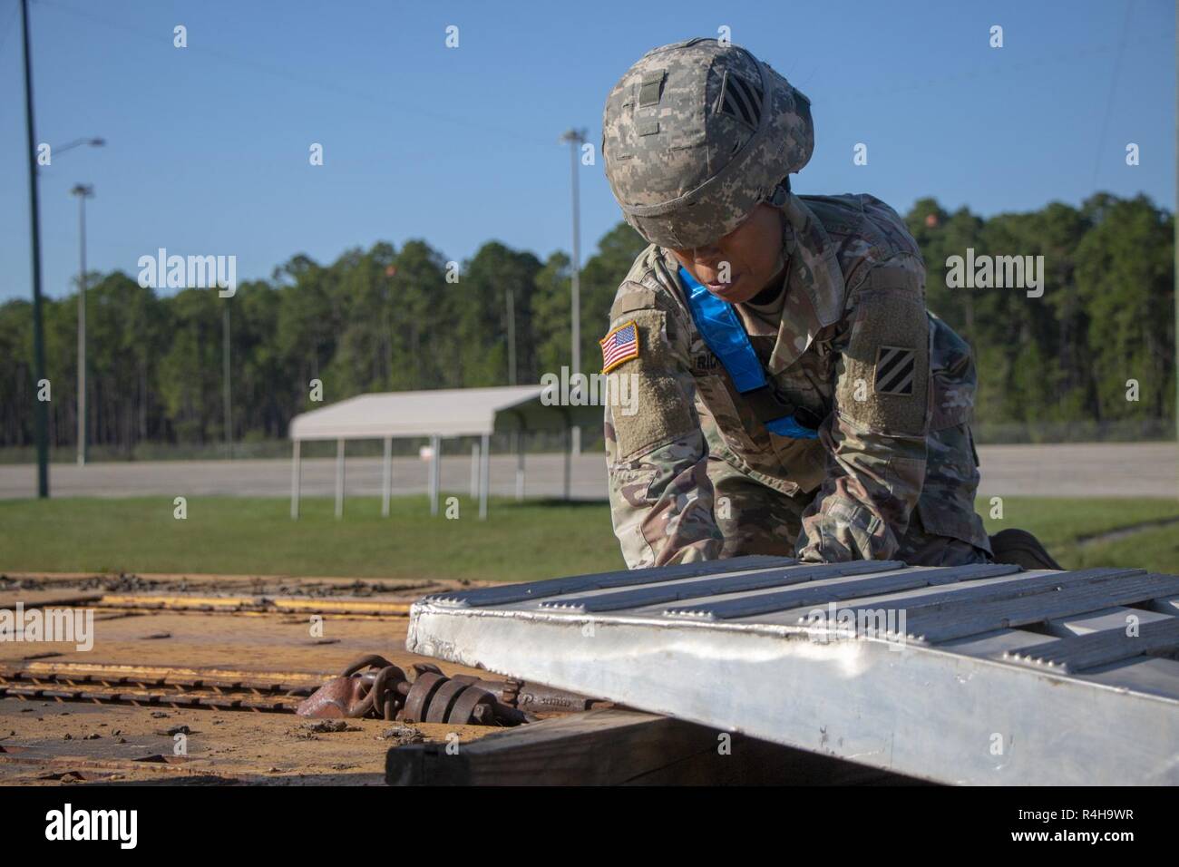 Spc Aleena Ricks an 2nd Battalion, 69th Armored Regiment, 2. gepanzerte Brigade Combat Team, strafft eine Rampe zwischen den Waggons in Fort Stewart, Ga., Okt. 3, 2018 beigefügt. Soldaten gebunden Rampen zwischen den Waggons, die Fahrzeuge zu leicht von den Wagen ohne Schäden. Stockfoto