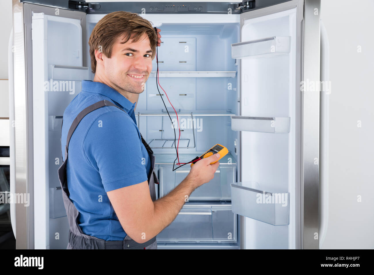 Männliche Techniker überprüfen Kühlschrank Stockfoto