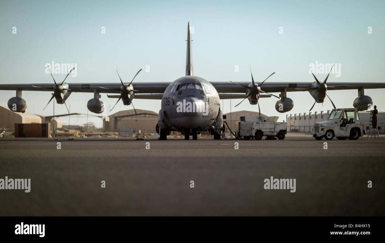 Unbekannten ORT, Südwesten Asien - EINE C-130J Super Hercules mit Marine Antenne Refueler Squadron 352 Distanz ein, Special Purpose Marine Air-Ground Task Force angebracht, Krise Response-Central Befehl, ist auf der Start- und Landebahn vor der Ausführung ein Luft-zu-Luft tanken mit U.S. Navy Helicopter meine Gegenmaßnahmen Squadron 15 Sept. 26, 2018 betankt. VMGR-352 Det. Eine führt regelmäßig Luft-zu-Luft tankt und Versorgung fällt in den Bereich der Betrieb einer Vielzahl von Missionen zu unterstützen. Stockfoto