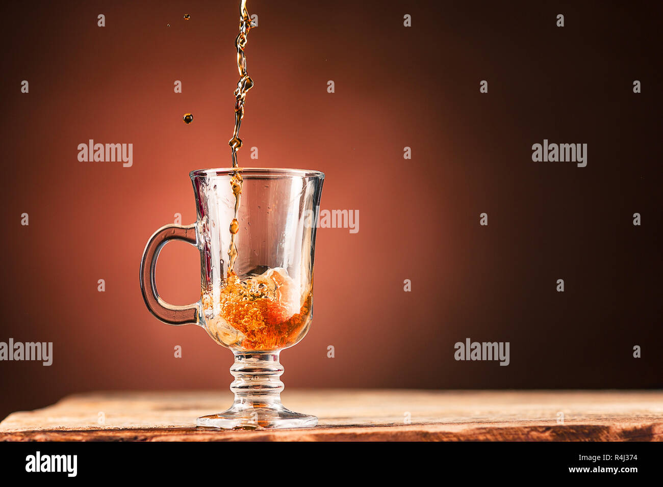 Braune Spritzer, Trinken aus der Tasse Tee auf einem braunen Hintergrund Stockfoto