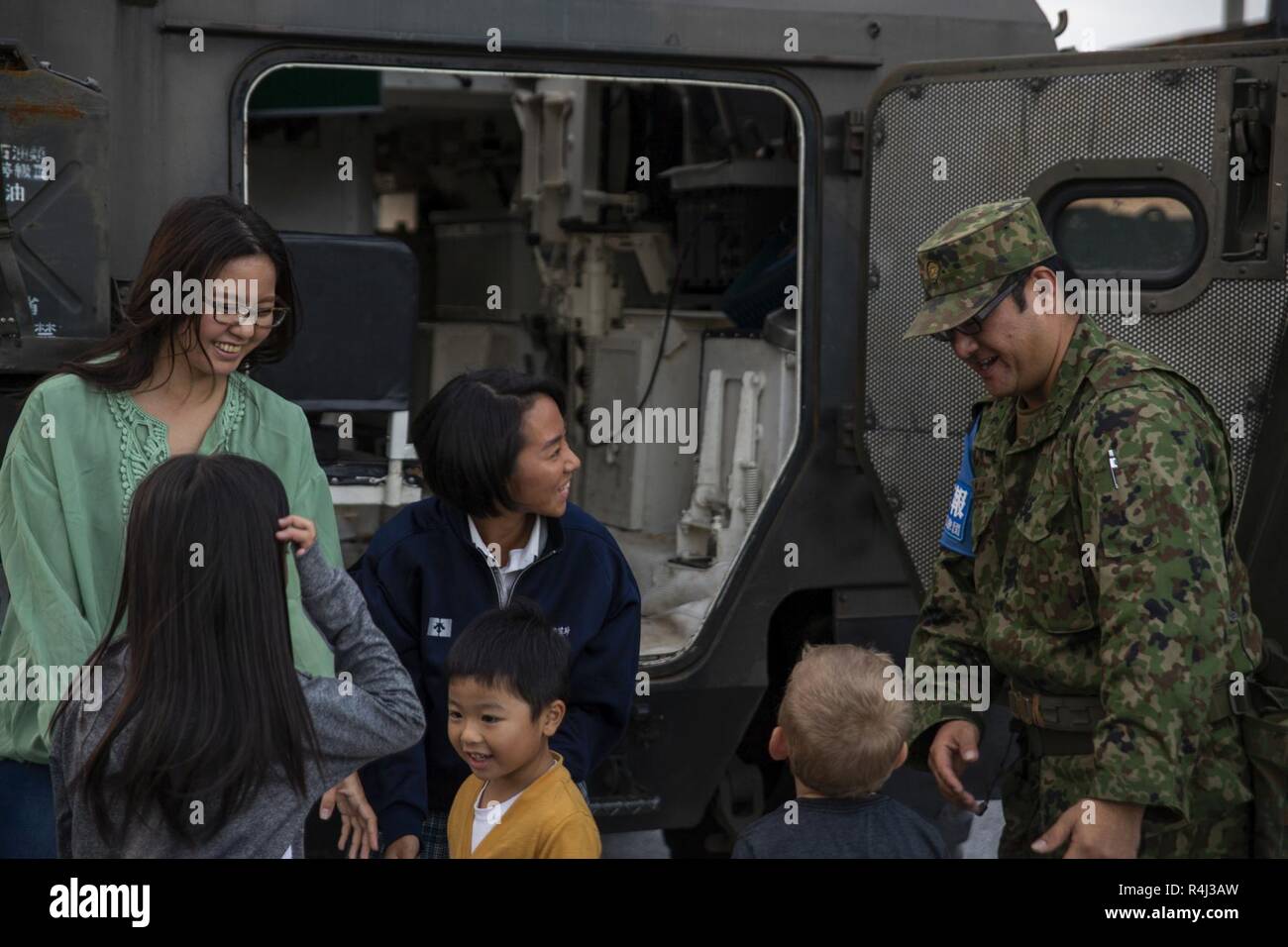 Ein Japan Masse Verteidigung-kraft service Mitglied und Okinawa Bewohner stehen neben einem JGSDF Fahrzeug während der kinser Festival auf Lager Kinser, Okinawa, Japan, 27.10.2018. Das Festival fand statt, der Japan-US-amerikanischen Beziehungen der Gemeinschaft zu Essen, Live-Musik, Spiele zu fördern. Stockfoto