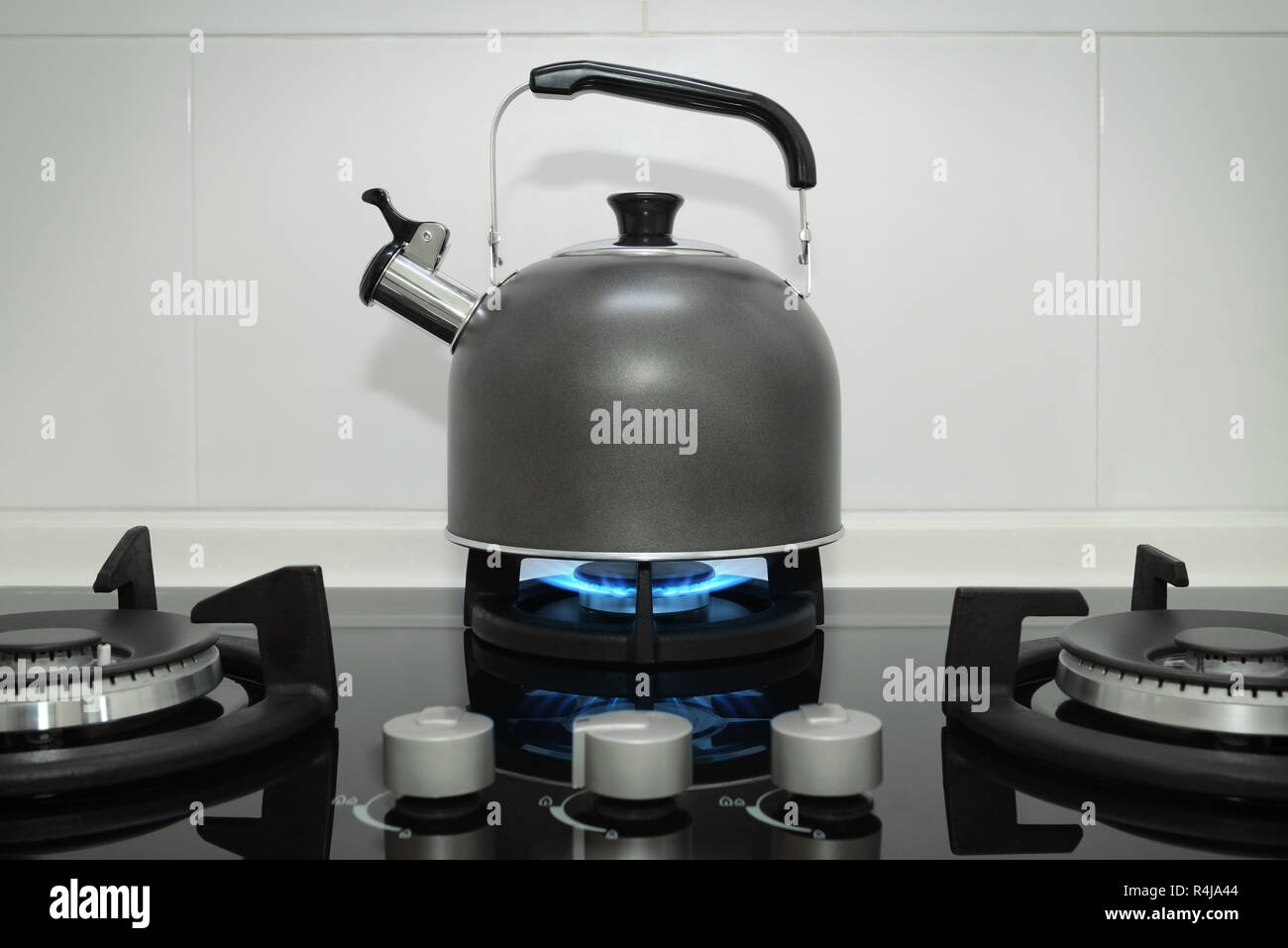 Edelstahl Wasserkocher auf einem Gasherd mit blauen Flammen Stockfoto