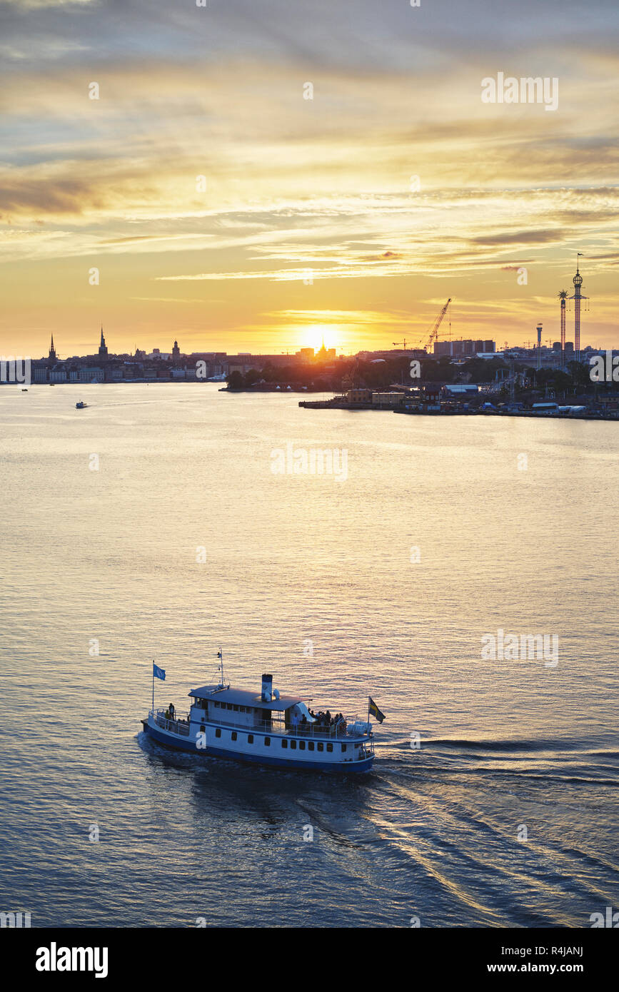 Fahrgastschiff auf dem Fluss bei Sonnenuntergang in Stockholm, Schweden Stockfoto