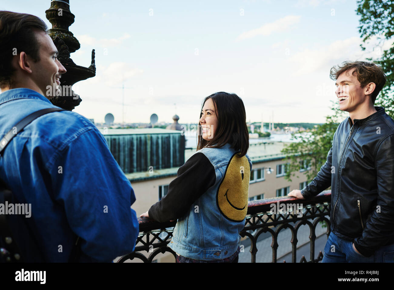 Freunde auf einem Balkon in Stockholm, Schweden lachen Stockfoto