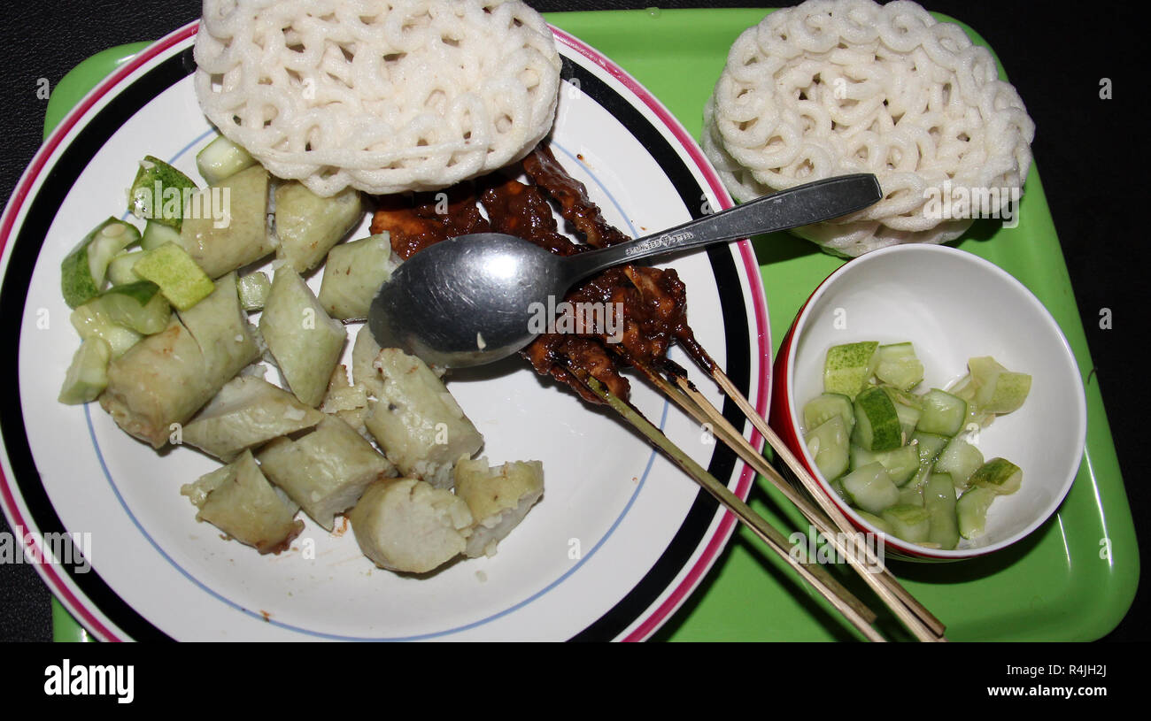 Platte von Reiskuchen (lontong) mit satay Sticks. Stockfoto