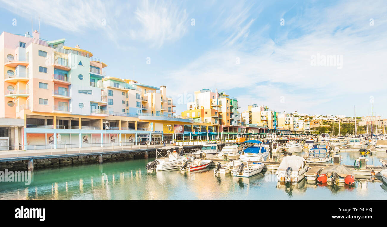 Sportboote am Jachthafen von Albufeira mit pastellfarbenen postmodernen Ferienwohnung Bausteine im Hintergrund Stockfoto