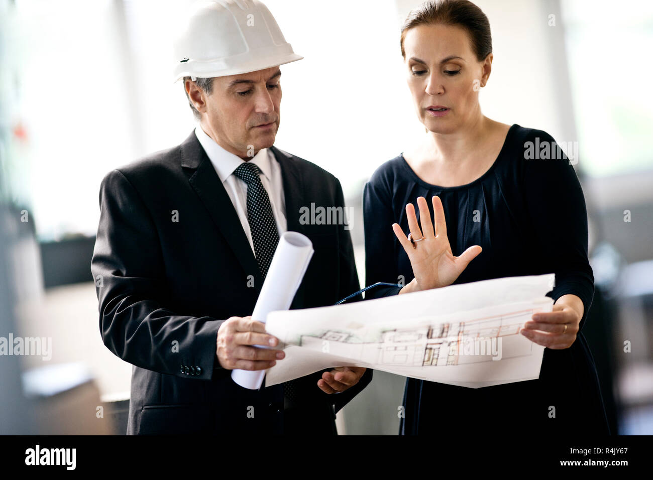 Architekt in hardhat diskutieren Blueprints mit Kunde. Stockfoto