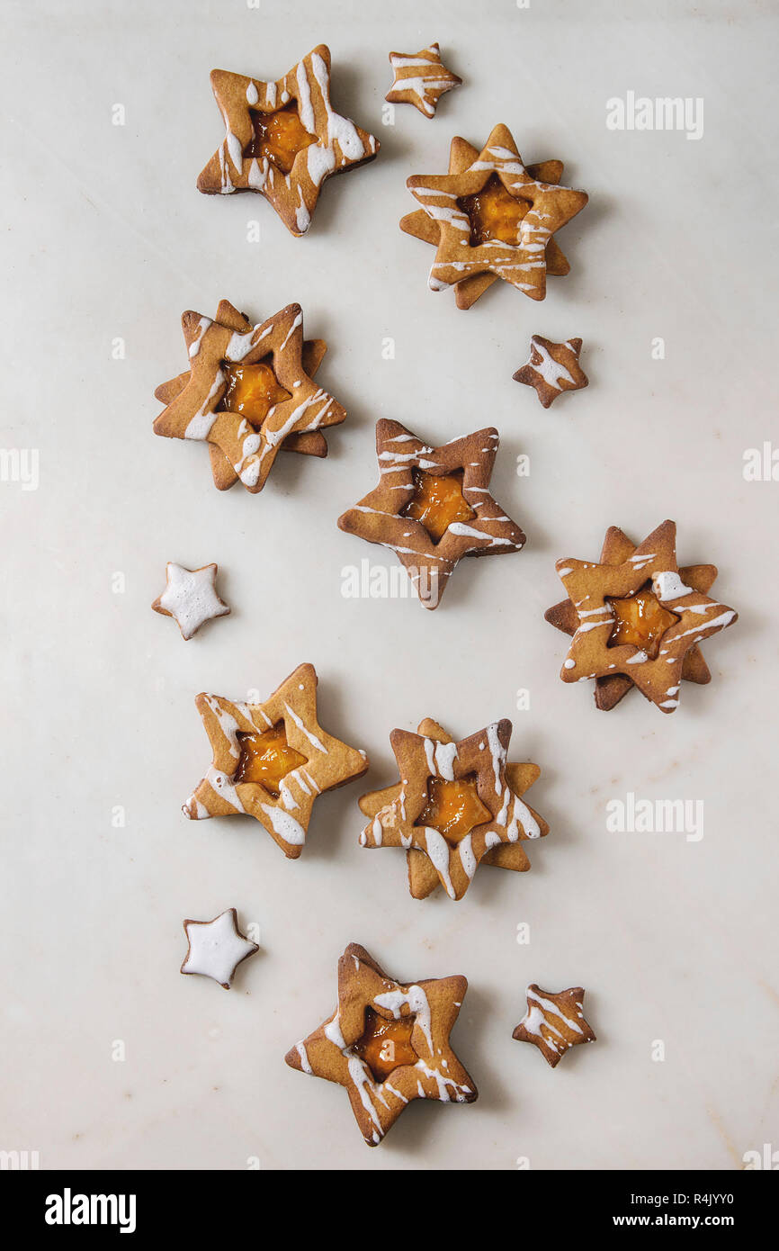 Hausgemachte Weihnachten Stern Zucker karamel Kekse mit Zuckerguss und orange Zitrus Marmelade über weißem Marmor Hintergrund. Flach, Platz. Süße Weihnachten oder n Stockfoto