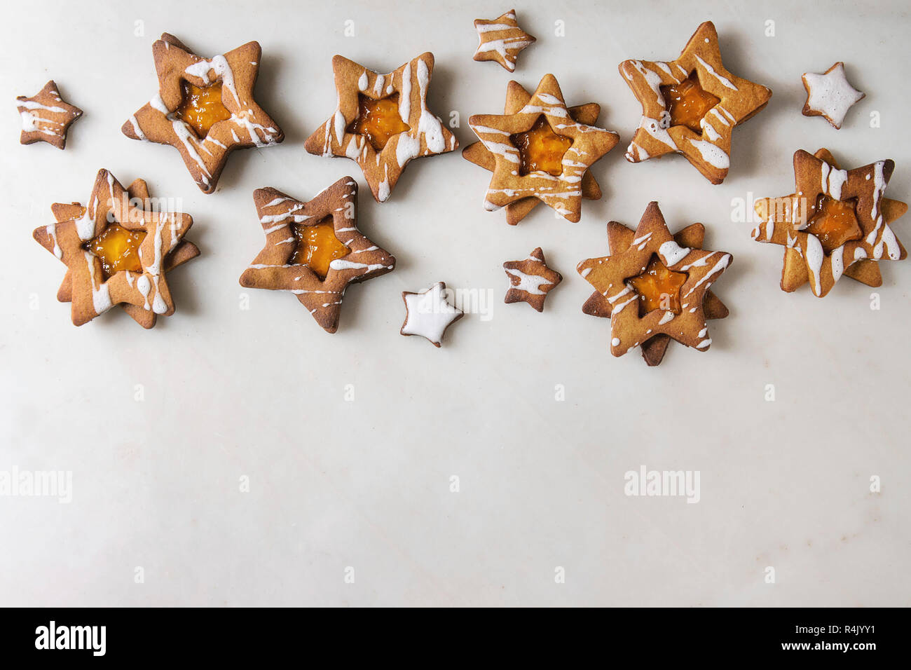 Hausgemachte Weihnachten Stern Zucker karamel Kekse mit Zuckerguss und orange Zitrus Marmelade über weißem Marmor Hintergrund. Flach, Platz. Süße Weihnachten oder n Stockfoto