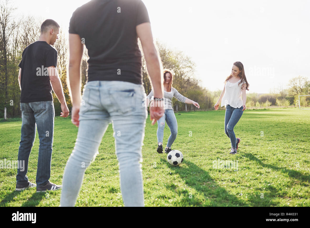 Eine Gruppe von Freunden im casual Outfit Fußball spielen im Freien. Leute  haben Spaß und Spaß haben. Aktive Erholung und einen malerischen  Sonnenuntergang Stockfotografie - Alamy