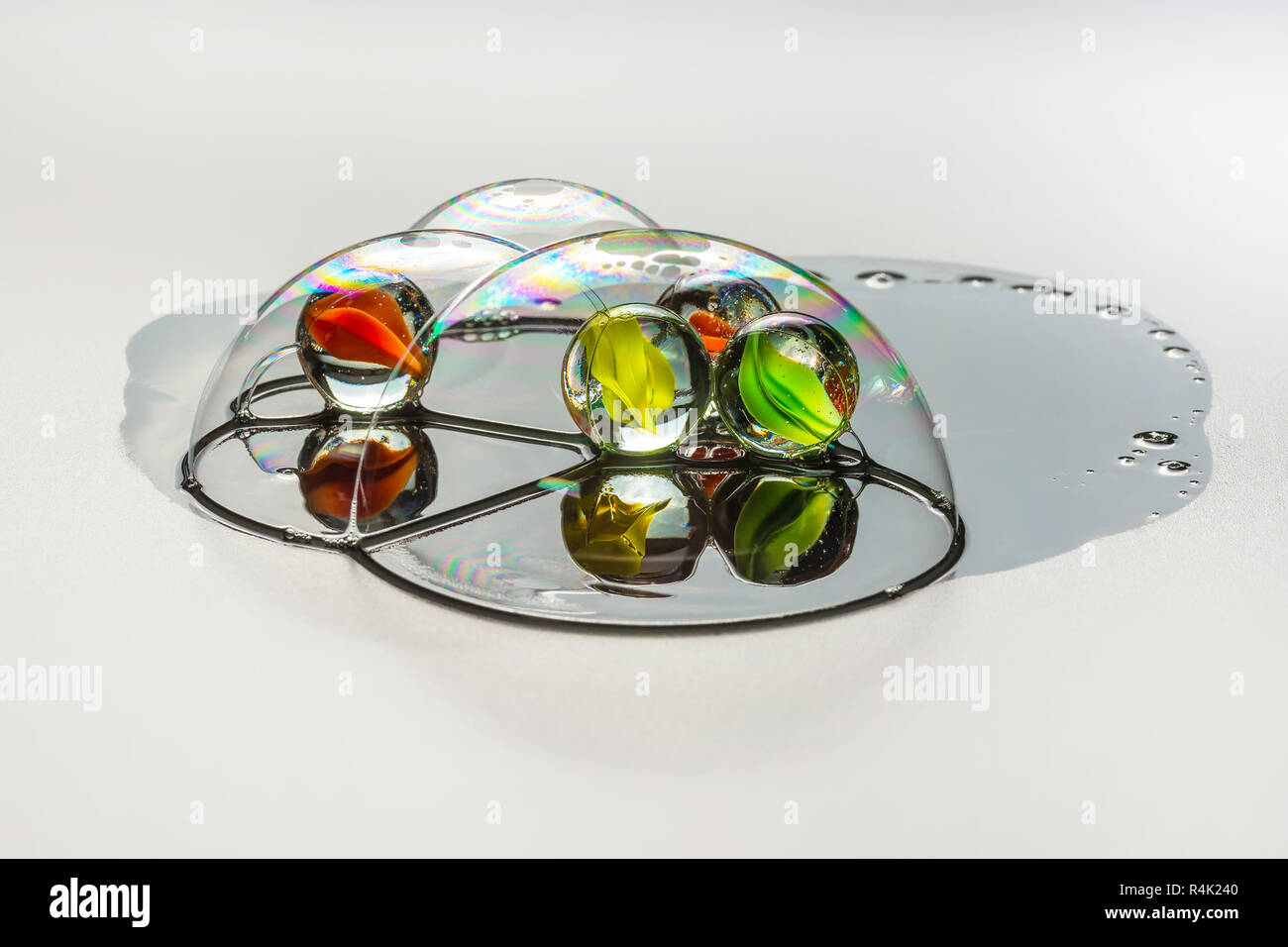 Vier mehrfarbige glas kugel innerhalb der Seifenblasen Stockfoto