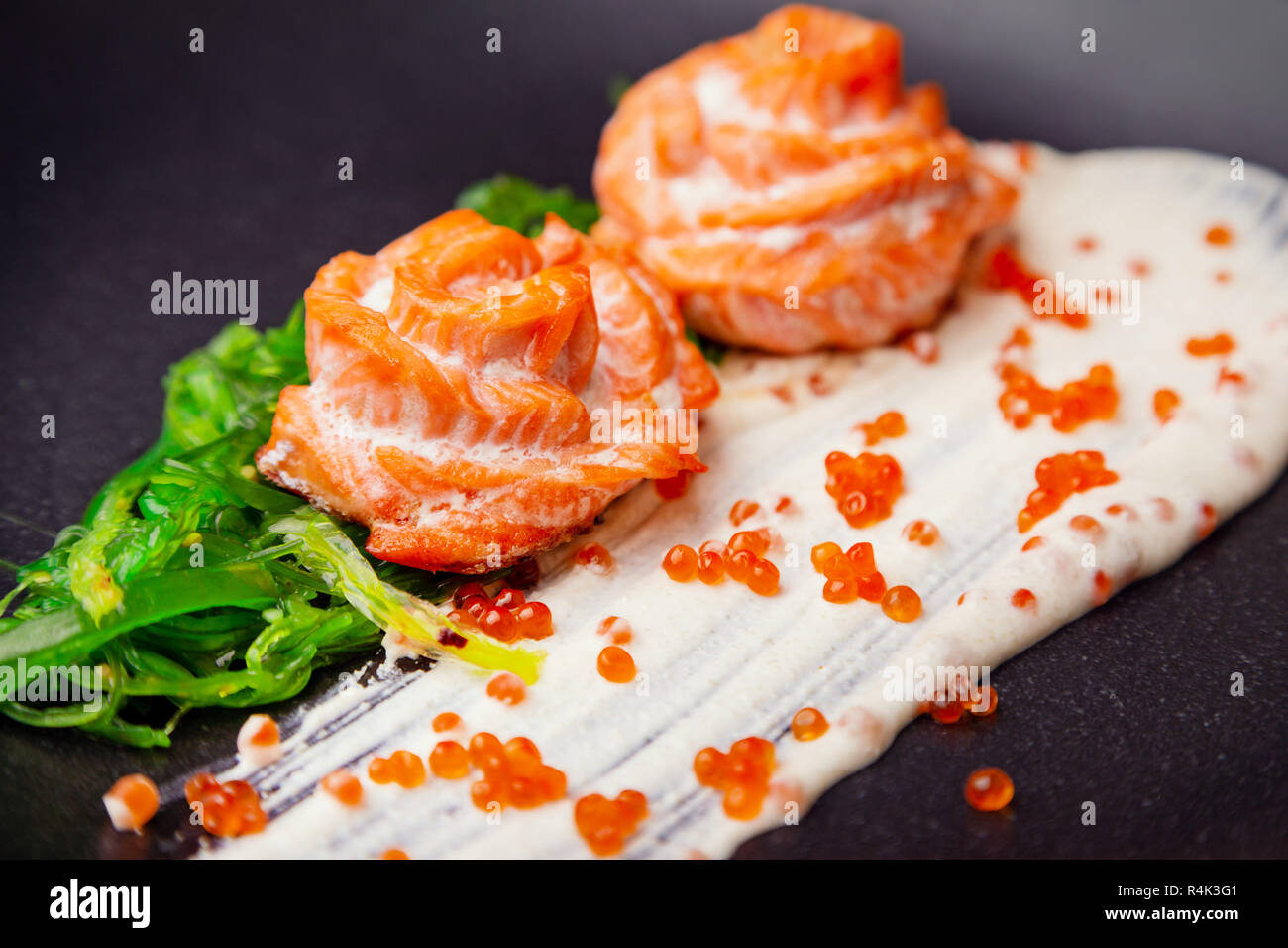 Gekochten gebackenen Lachs in Sahnesoße garniert mit hiyashi Algen und roter Kaviar Stockfoto