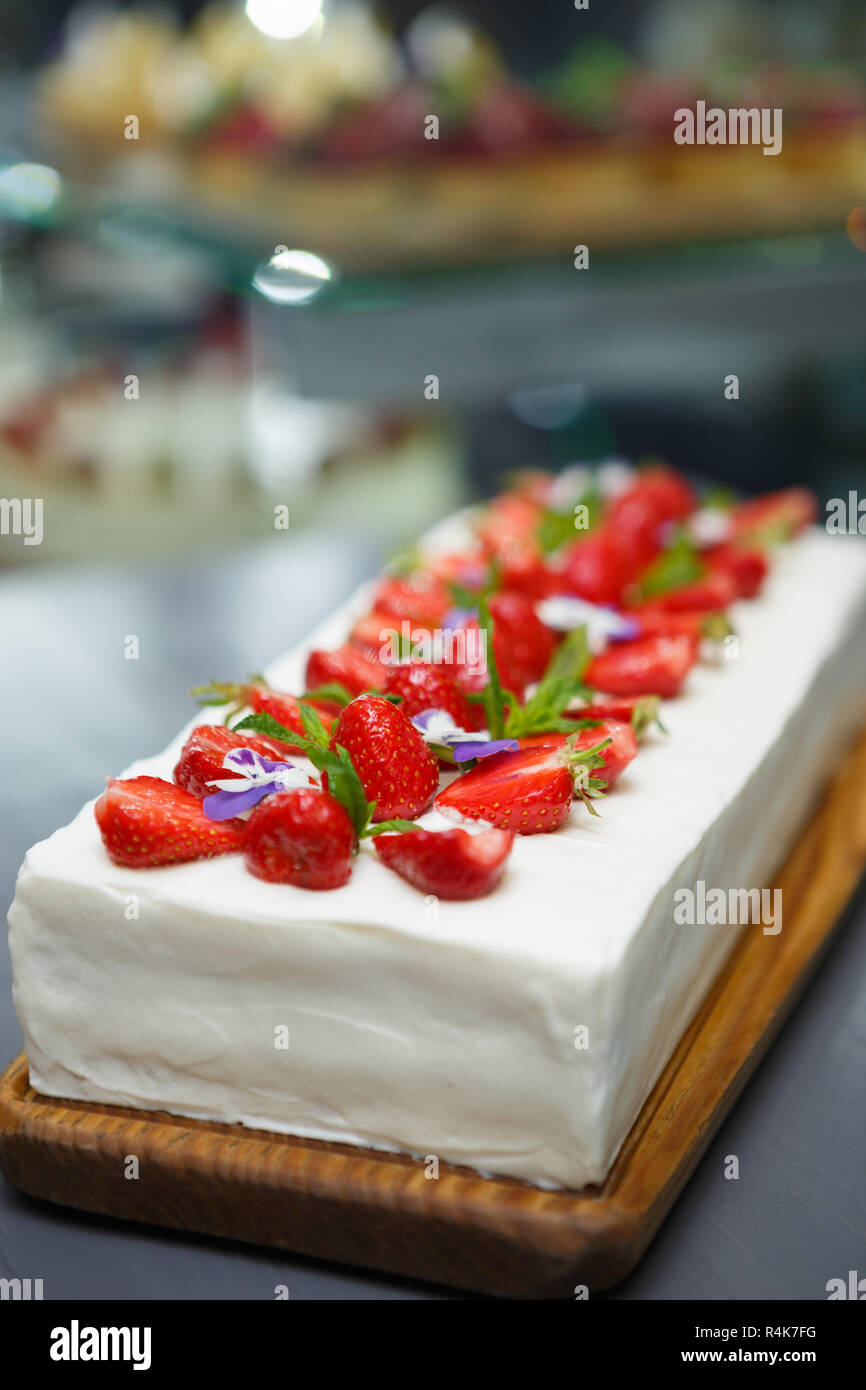 Köstliche weiße cremige Erdbeertorte in italienischen Bäckerei Cafe. Genießen Sie leckere süße Nachspeise Schale mit frischen Erdbeeren auf nachfüllen Stockfoto