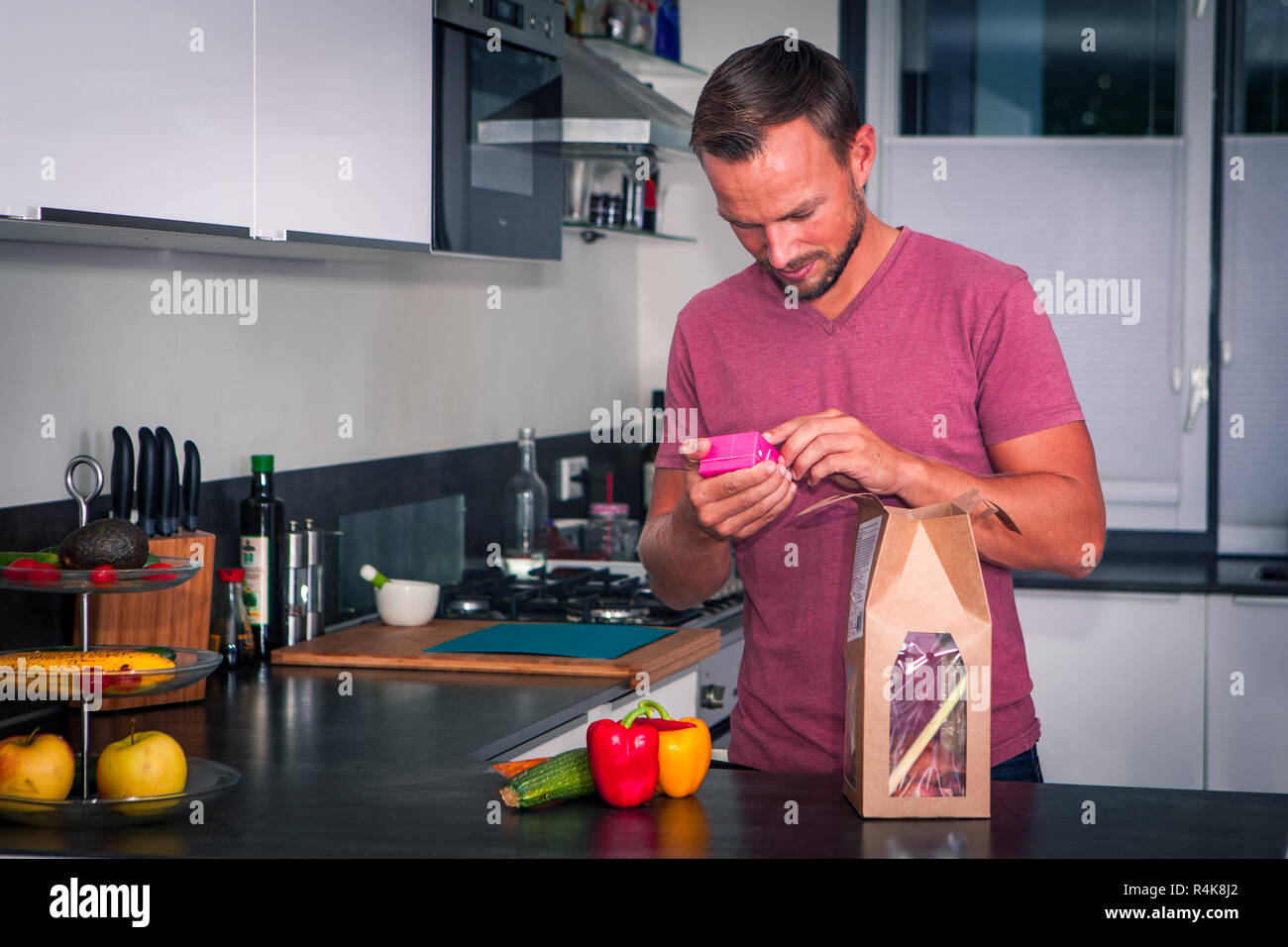 Junge Mann in der Küche und lesen das Paket Stockfoto