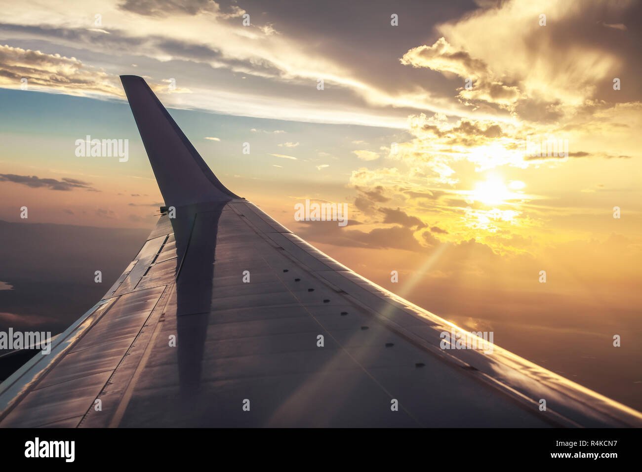 Blick auf flugzeugflügel von Flugzeugen im Sonnenuntergang. Travel Concept Stockfoto