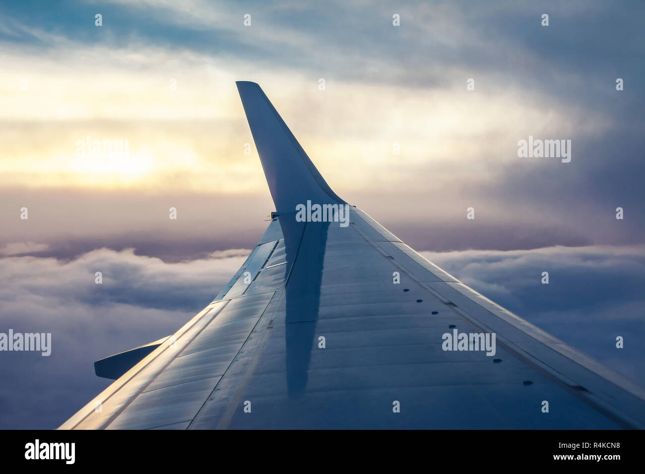 Blick auf flugzeugflügel von Flugzeugen im Sonnenuntergang. Travel Concept Stockfoto
