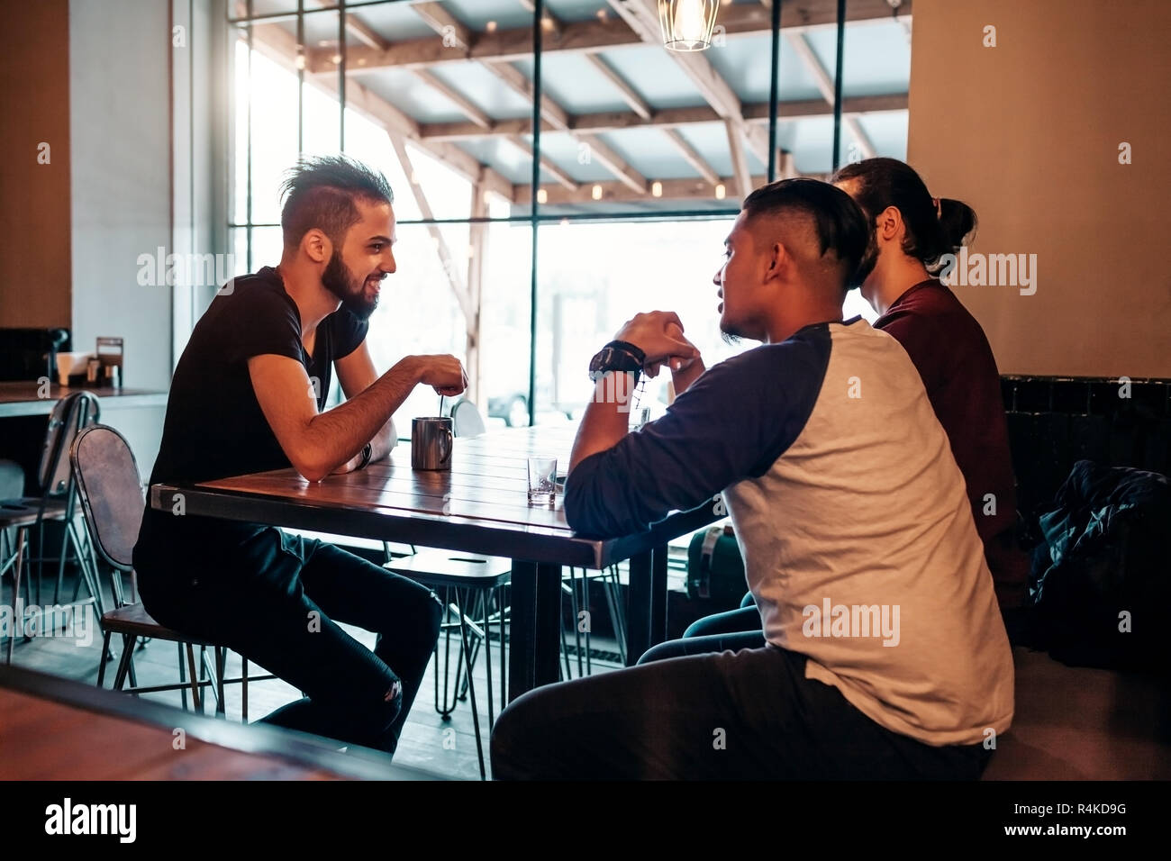 Arabische junge Männer hängen in loft Café. Aus dem Nahen Osten die Menschen reden und Spaß haben in der Lounge Bar und etwas trinken. Freunde Chillen und Relaxin Stockfoto
